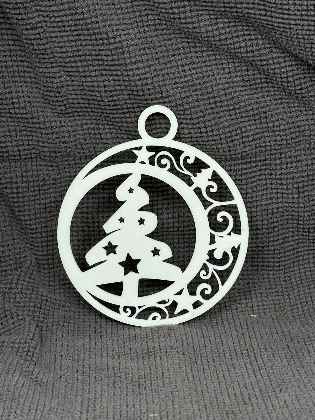 Rund julgransprydnad med julgran och stjärnor