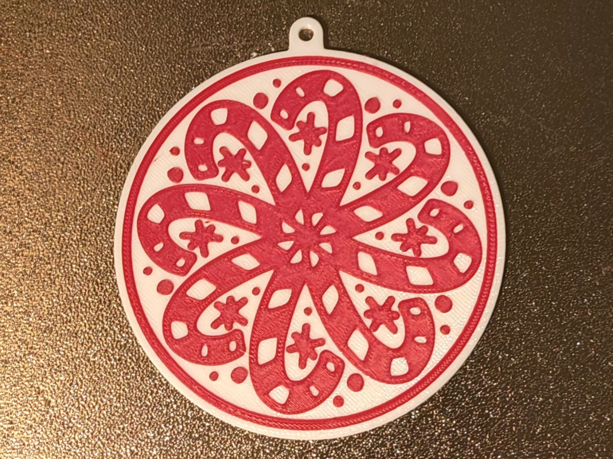 Rund julgransprydnad med polkagrisar formade som en snöflinga