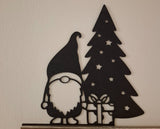 Tomtefigur med present vid julgranen