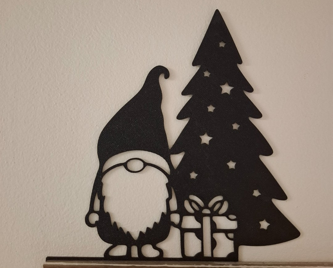 Tomtefigur med present vid julgranen