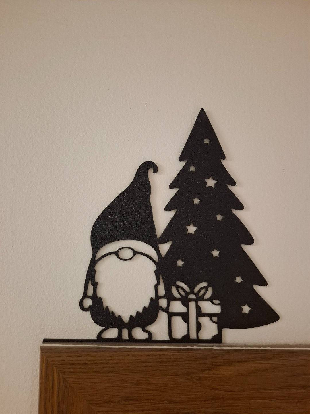 Tomtefigur med present vid julgranen