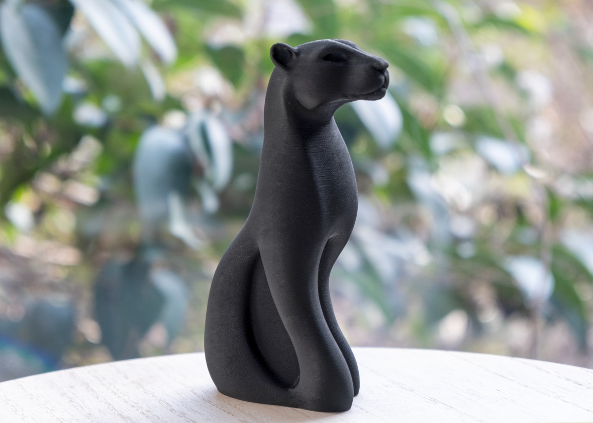 Svart panterskulptur på en skänk i trä med minimalistisk skandinavisk inredning