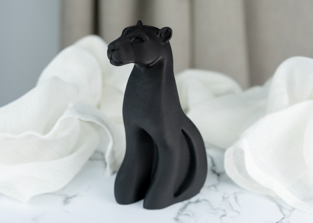 Detalj av pantherskulptur med flytande siluett i matt svart