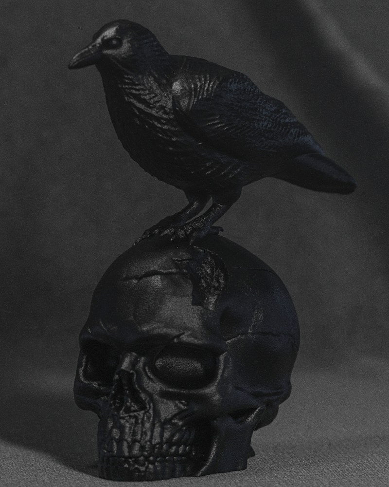 Närbild av en skulptur med en mörk korp på en sprucken människoskalle