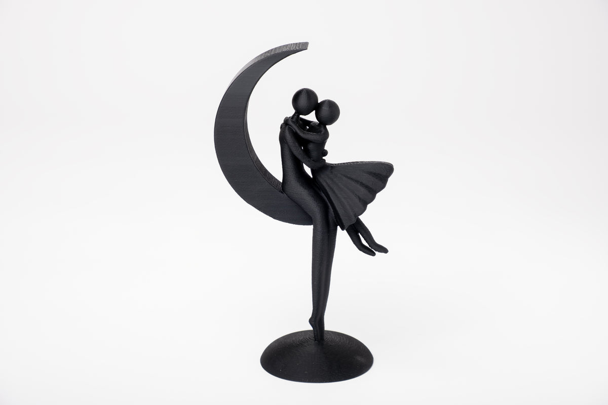 Minimalistisk skulptur av ett par på månen på en trähylla med mjuk neutral inredning