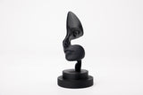 Note of Emotion – abstrakt svart skulptur på en minimalistisk hylla med böcker och ett ljus