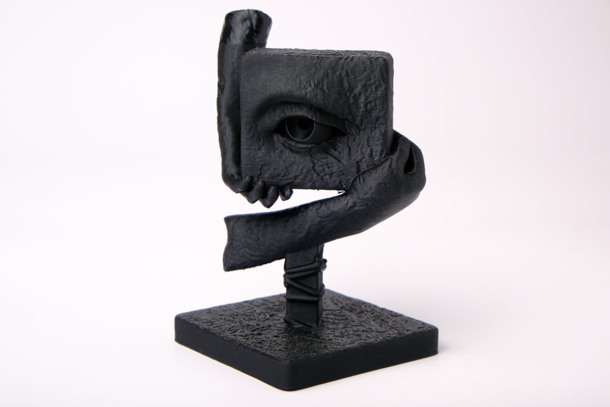The Witness – surrealistisk skulptur på ett mörkt skrivbord i trä med minimalistisk inredning