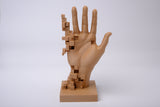 Handskulptur i glitch art-stil på minimalistiskt skrivbord med böcker och liten växt
