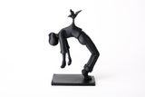 Bird of Burden-skulptur på en minimalistisk trähylla bredvid böcker och ett litet keramikkärl