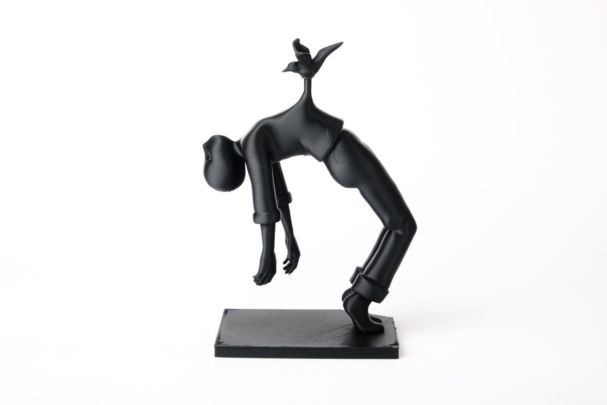 Bird of Burden-skulptur på en minimalistisk trähylla bredvid böcker och ett litet keramikkärl