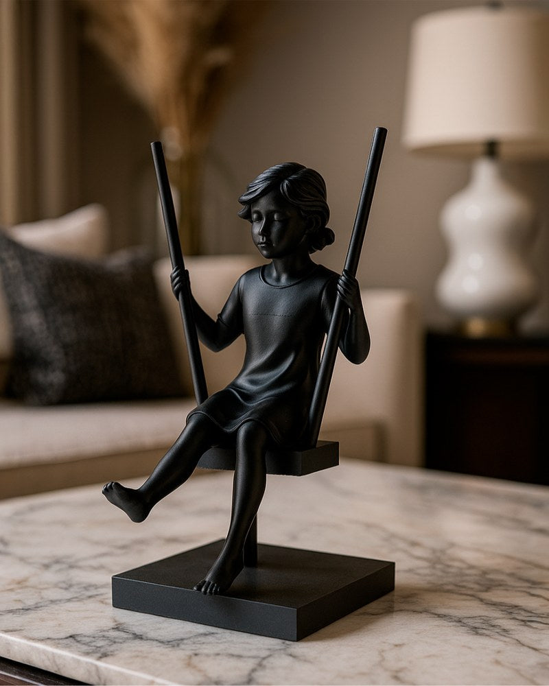 Minimalistisk skulptur av en flicka på en gunga i matt finish, framifrån på vit yta