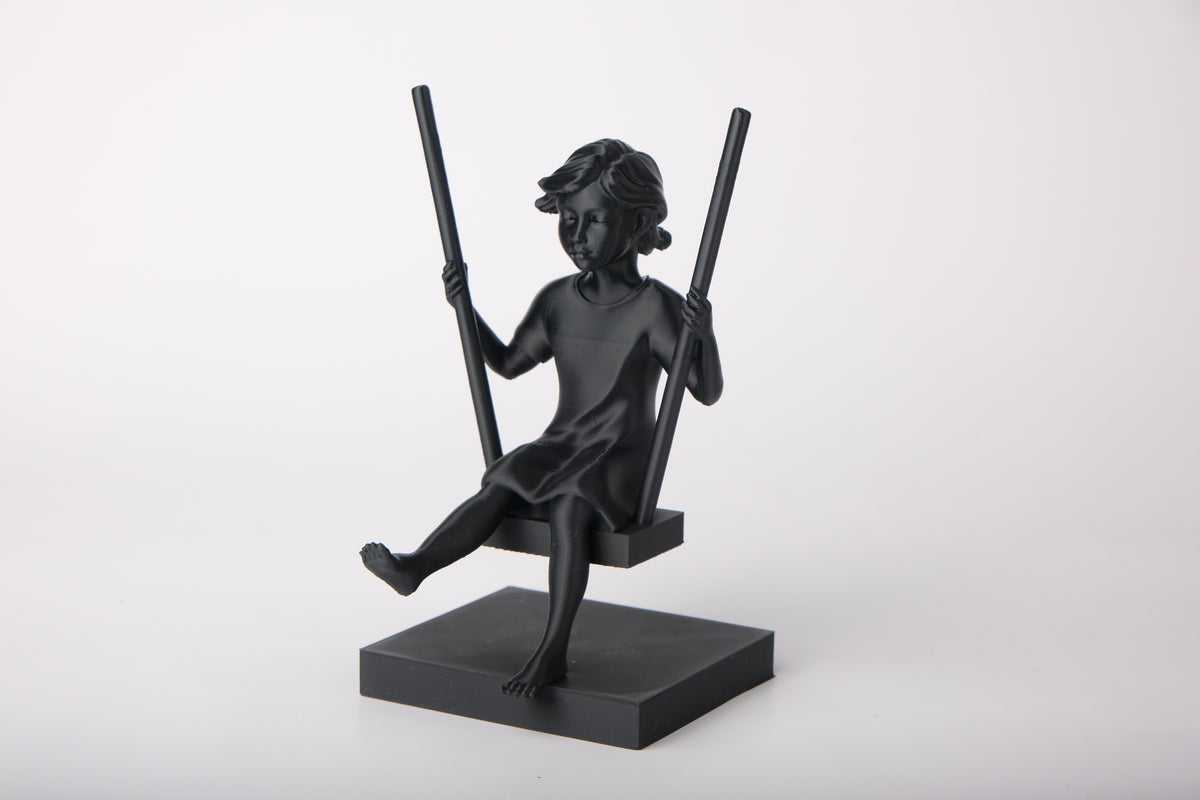 Skulptur av flicka på gunga på trähylla med neutral skandinavisk inredning