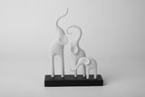 Minimalistisk skulptur av en elefantfamilj på en ljus trähylla med neutral skandinavisk inredning