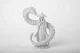 Fantasyskulptur av drakväktare på minimalistisk mörk trähylla