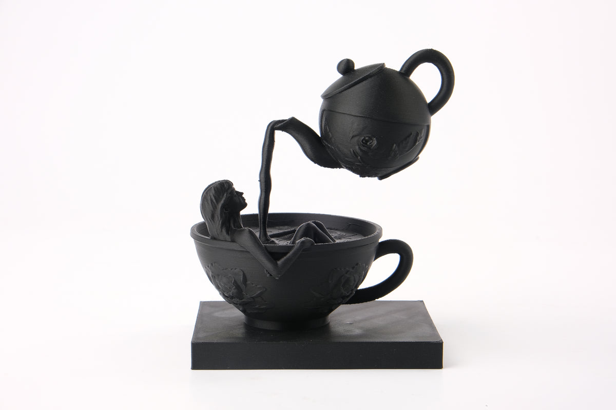 Skulpturen Tea Time Reverie på en mörk hylla med böcker och minimalistisk inredning