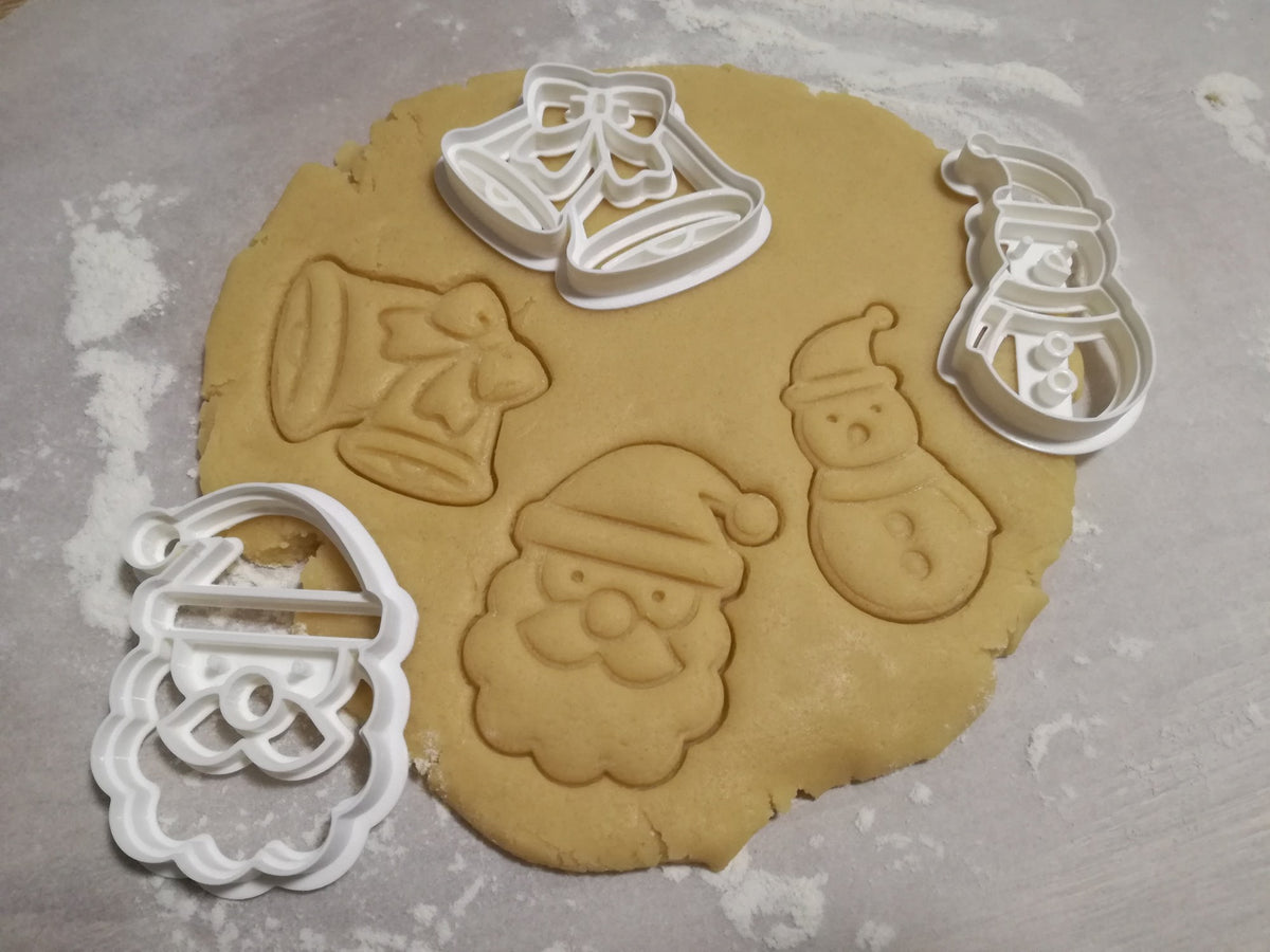 Tre pepparkaksformar: jultomte, snögubbe och julklockor