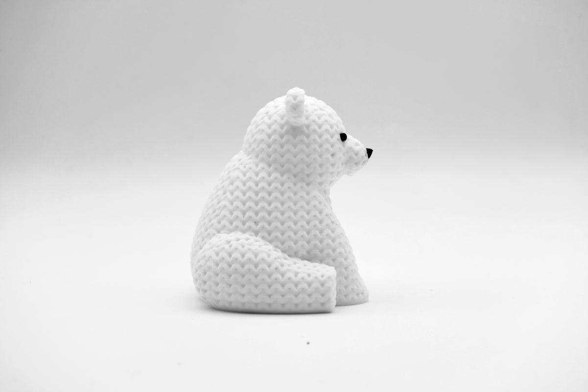 Närbild av en liten vit stickad isbjörnsfigur med virkad look, 8 cm hög