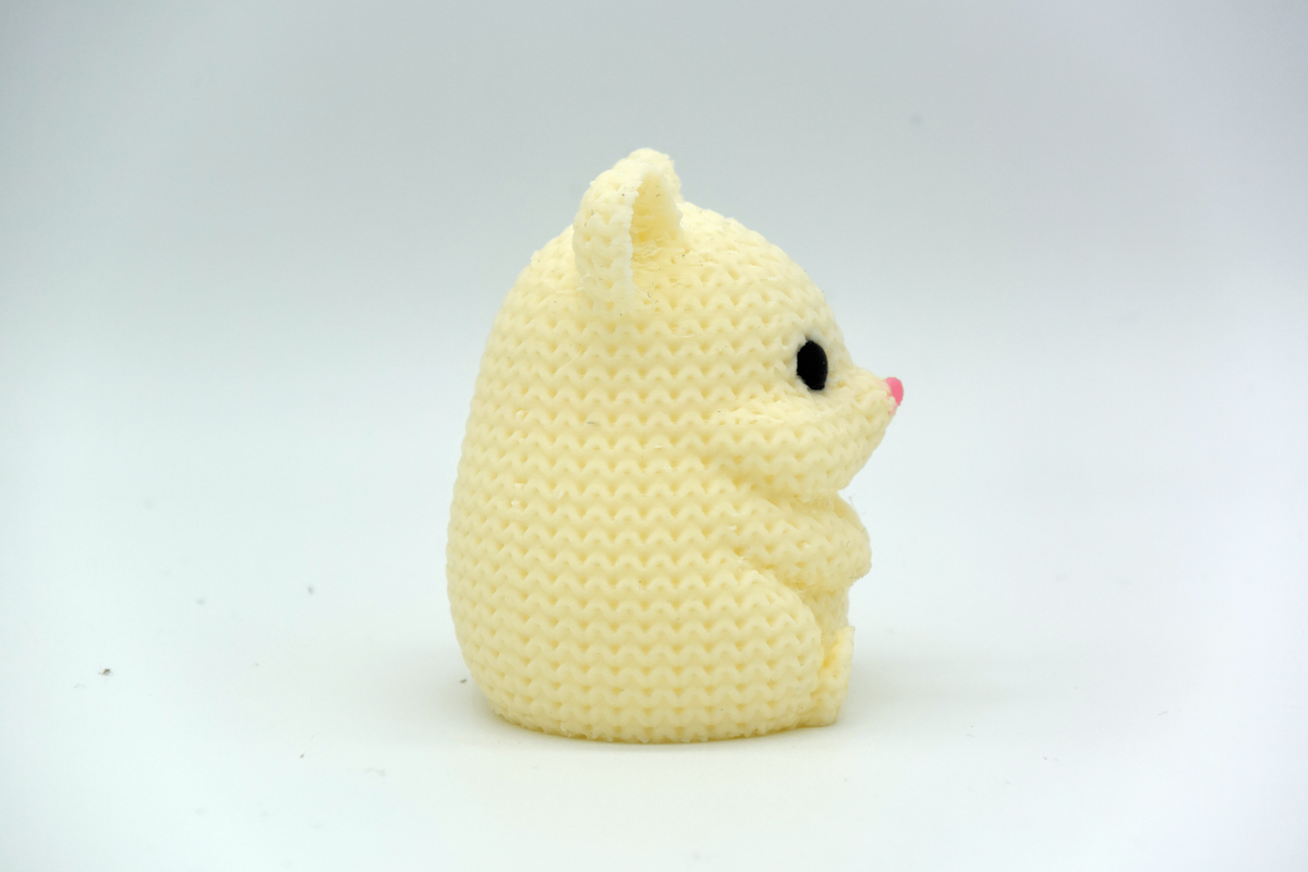 Närbild av en stickad hamster med virkad look och små runda ögon och nos