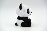 Närbild av stickad pandas maskmönster i svart och vitt