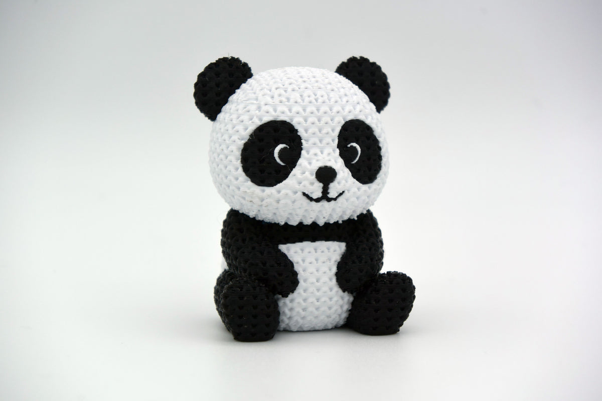 Närbild av en stickad pandafigur med svartvit virkad look