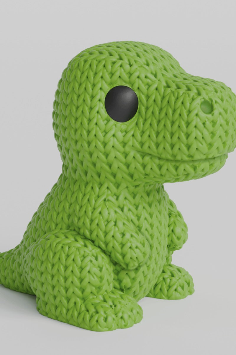 Närbild av en stickad T-Rex-figur i salviagrönt med virkad look