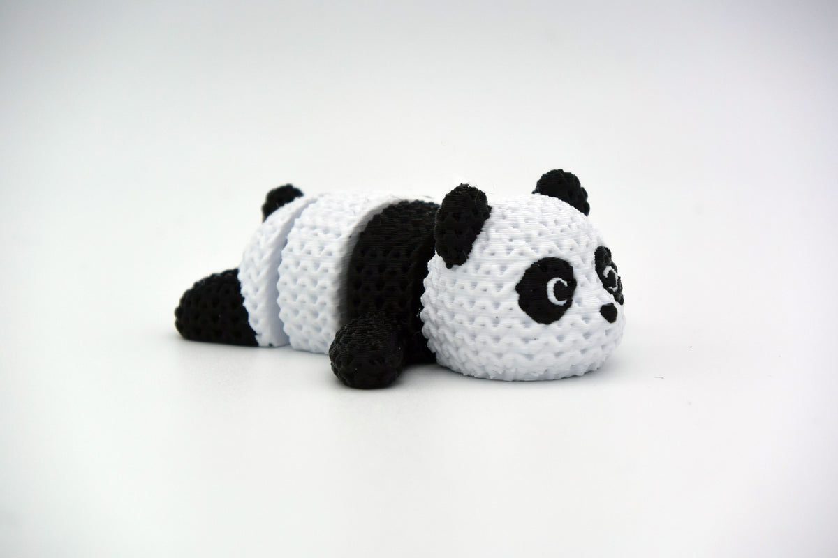 Stickad ledad pandafigur i svart och vitt med virkad look, närbild