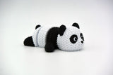 Stickad ledad pandafigur i svart och vitt med virkad look, närbild