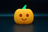 Strukturdetalj av en stickad halloweenpumpa med vävt mönster och utskuret ansikte