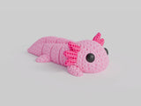 Närbild av en stickad axolotlfigur i ljusrosa med virkad textur