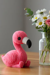 Närbild av en rosa stickad flamingofigur med virkad look, stående upprätt