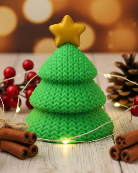 Närbild av en stickad julgransdekoration med öppen virkad look och liten stjärna i toppen