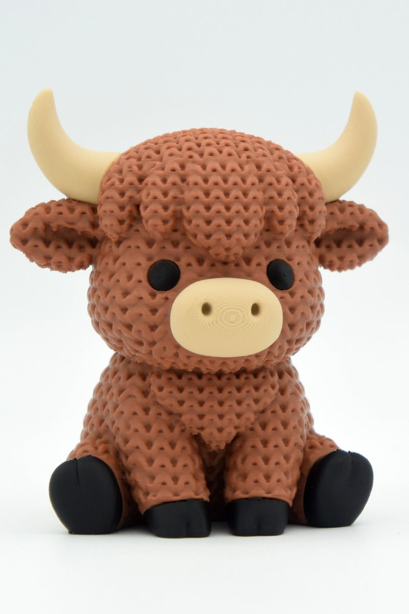 Närbild av en stickad highlandkofigur med virkad päls och små skulpterade horn