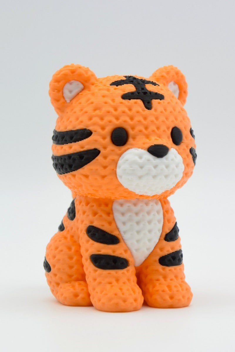 Närbild av en stickad tigerfigur med garnliknande yta och kraftiga orange och svarta ränder