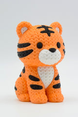 Närbild av en stickad tigerfigur med garnliknande yta och kraftiga orange och svarta ränder