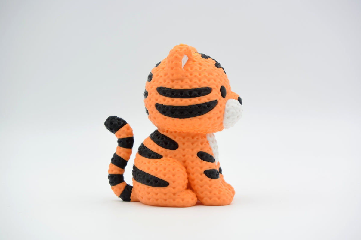Liten stickad tiger på en trähylla bredvid växter i ett skandinaviskt vardagsrum