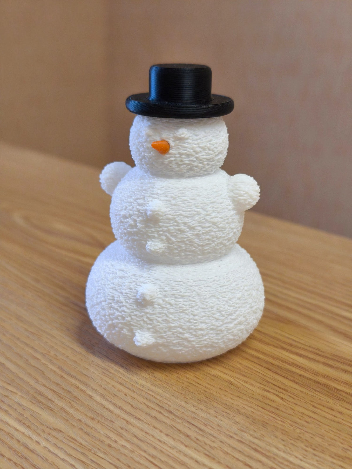 Snögubbe med hatt och näsa över ett LED-värmeljus