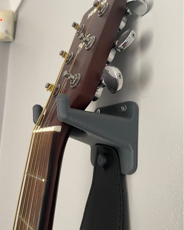 Väggfäste för gitarr med plektrumhållare och bandkrok
