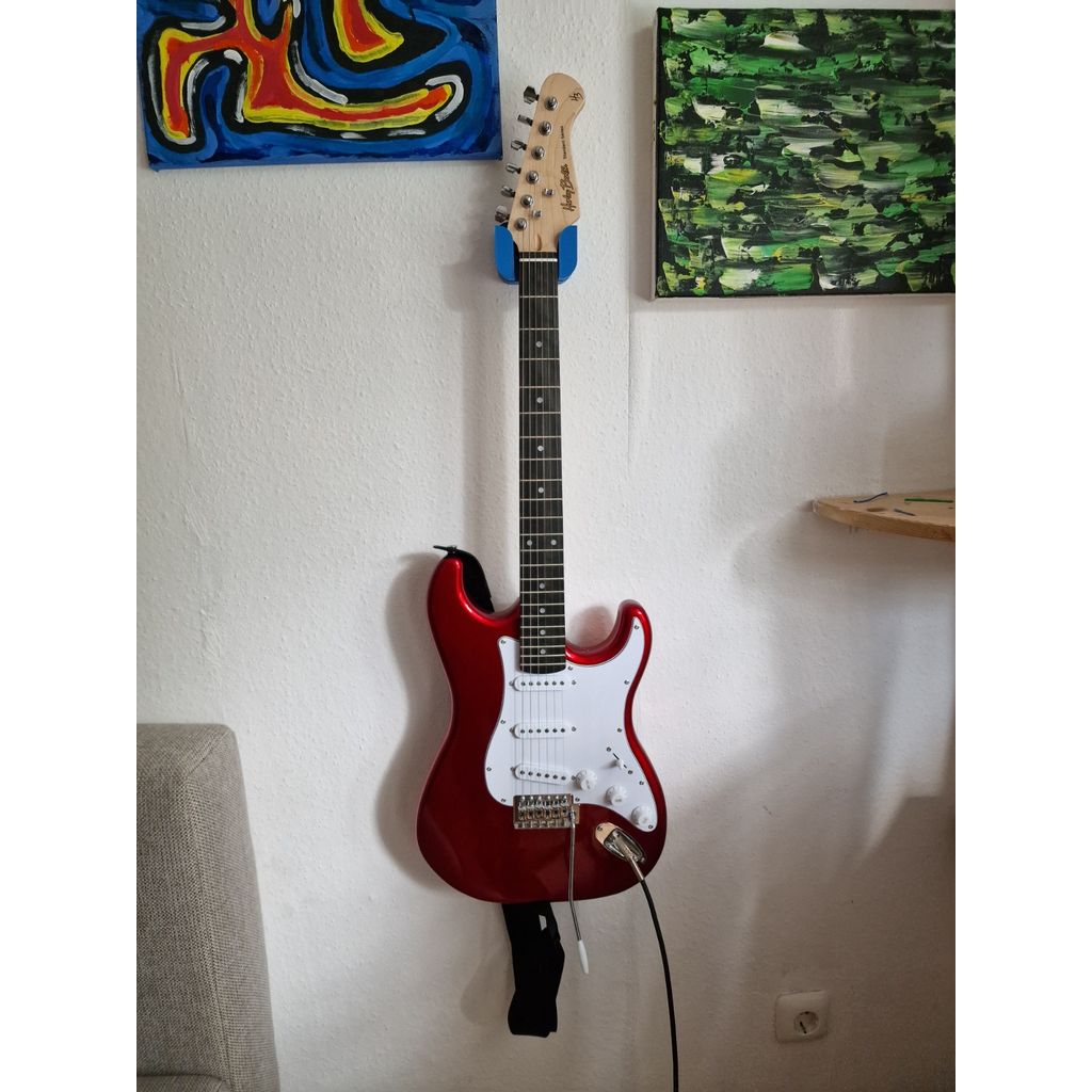 Väggfäste för gitarr med plats för plektrum